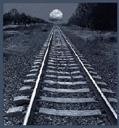 Railroad tracks with moon in background