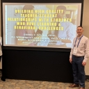 Dr. Van Horne and Daniel posing in front of a yellow powerpoint screen.