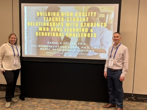 Dr. Van Horne and Daniel posing in front of a yellow powerpoint screen.